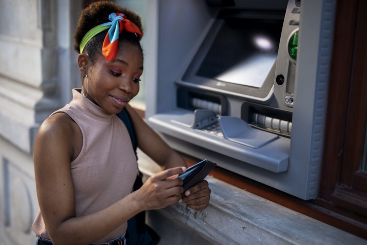 Woman smiling in front of an ATM